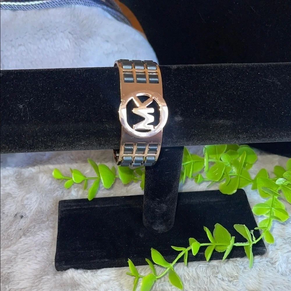 gold bracelet with black leather straps
